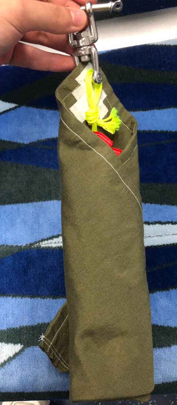 Parachute packed in its deployment bag with swivel