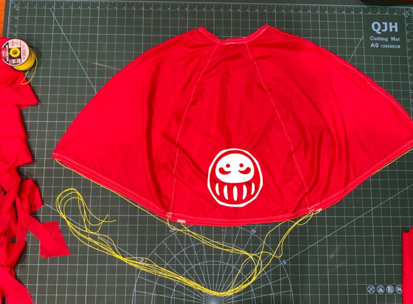 Custom red 6-gore parachute laid out on a cutting mat